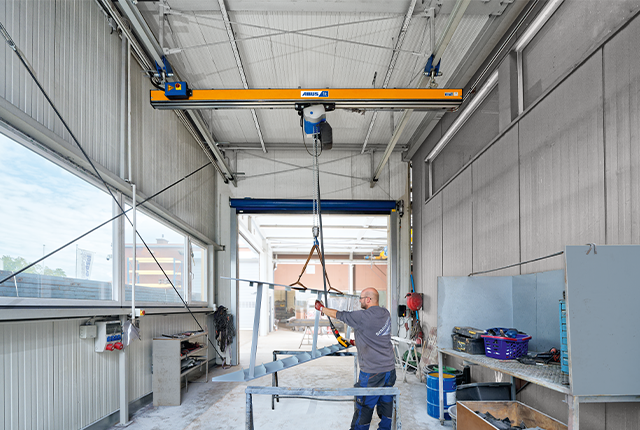 Grúa monorraíl ABUS EHB-I en una nave industrial, con una capacidad de carga de hasta 1,25 toneladas y una luz de hasta 10 metros.