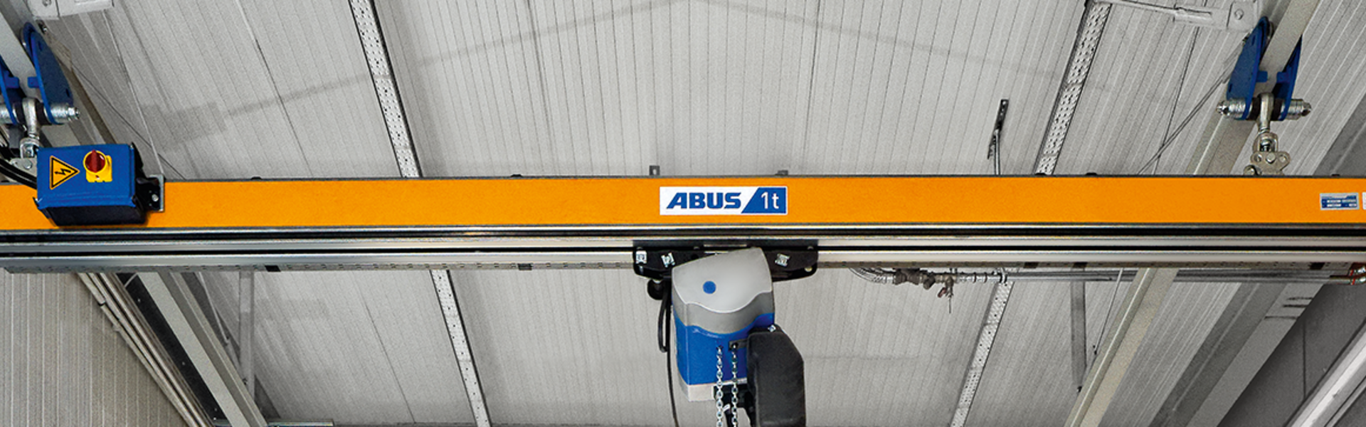 Grúa monorraíl ABUS EHB-I en una nave industrial para una elevación precisa y un transporte eficiente de materiales.