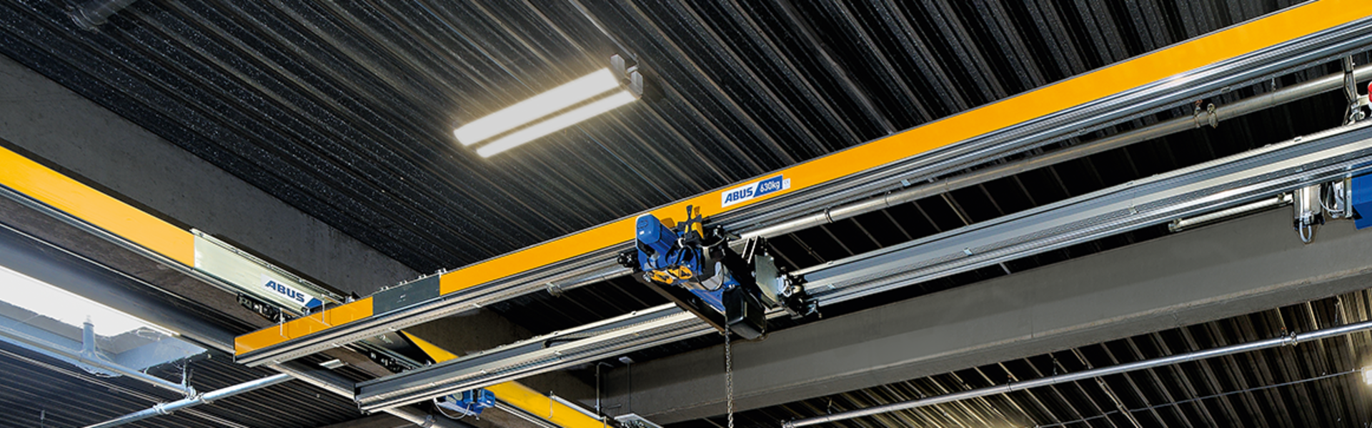 Grúa de dos vigas ABUS ZHB en una nave industrial para el transporte y la elevación seguros de cargas pesadas.