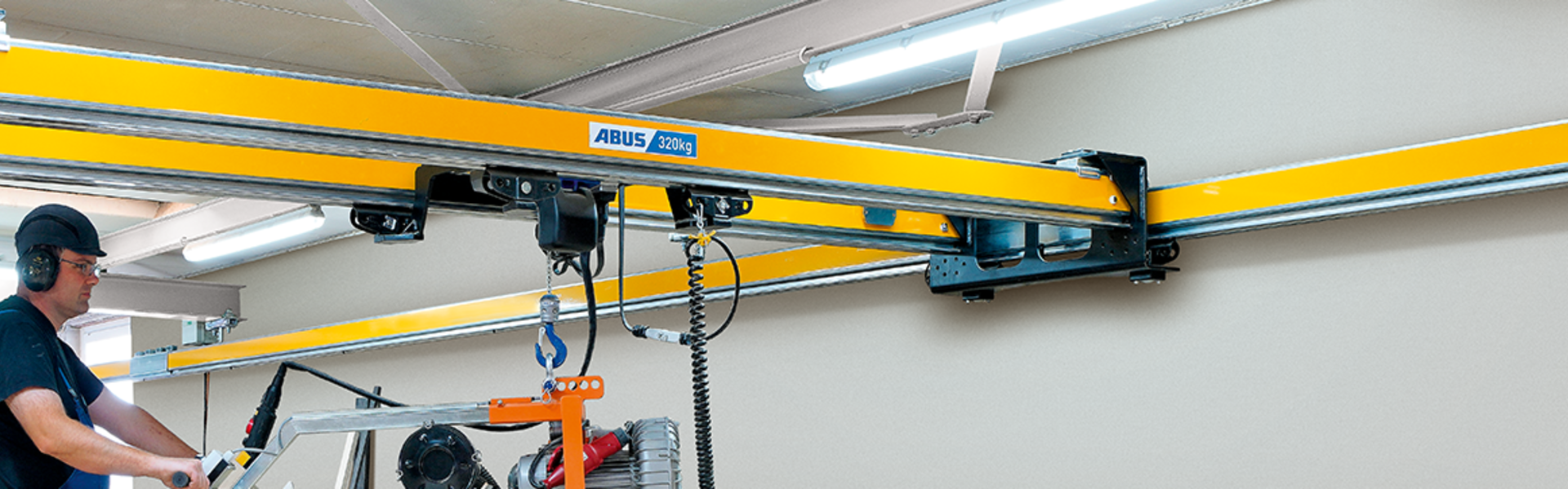 Grúa de dos vigas ABUS ZHB-X en una nave industrial para una elevación segura y un transporte eficiente de materiales.