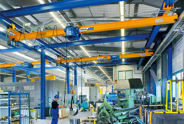 Grúas puente ABUS en una nave industrial con una capacidad de carga de hasta 8 t y una luz de hasta 25 m para el transporte de materiales que ahorra espacio.